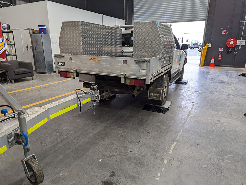 Image of a ute with connected boat trailer at the City of Gold Coast storage facility in Southport. The ute is on a mobile weighbridge from Gold Coast Mobile Weigh.
